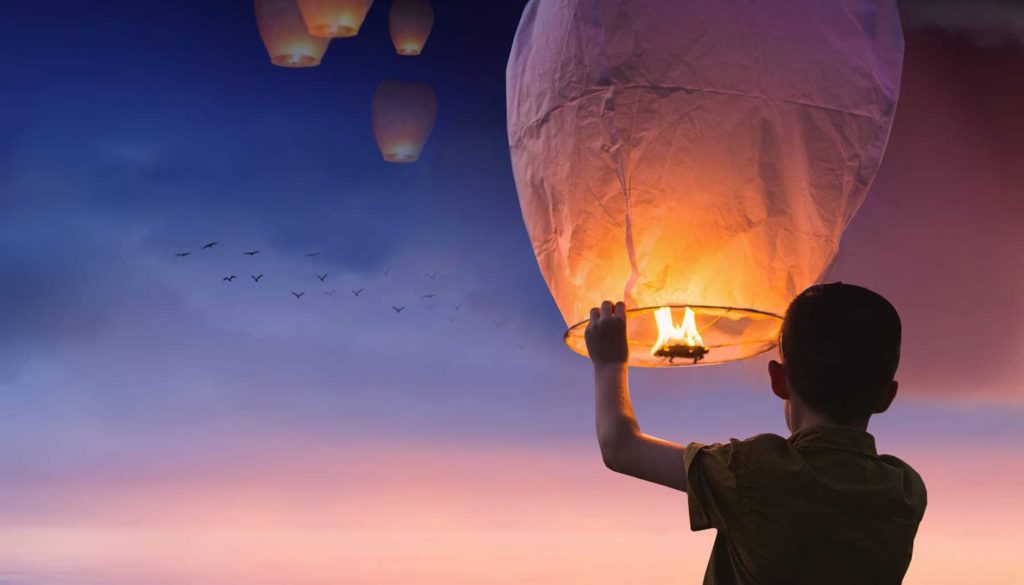 Kind mit Feuer unter Ballon der fliegen wird