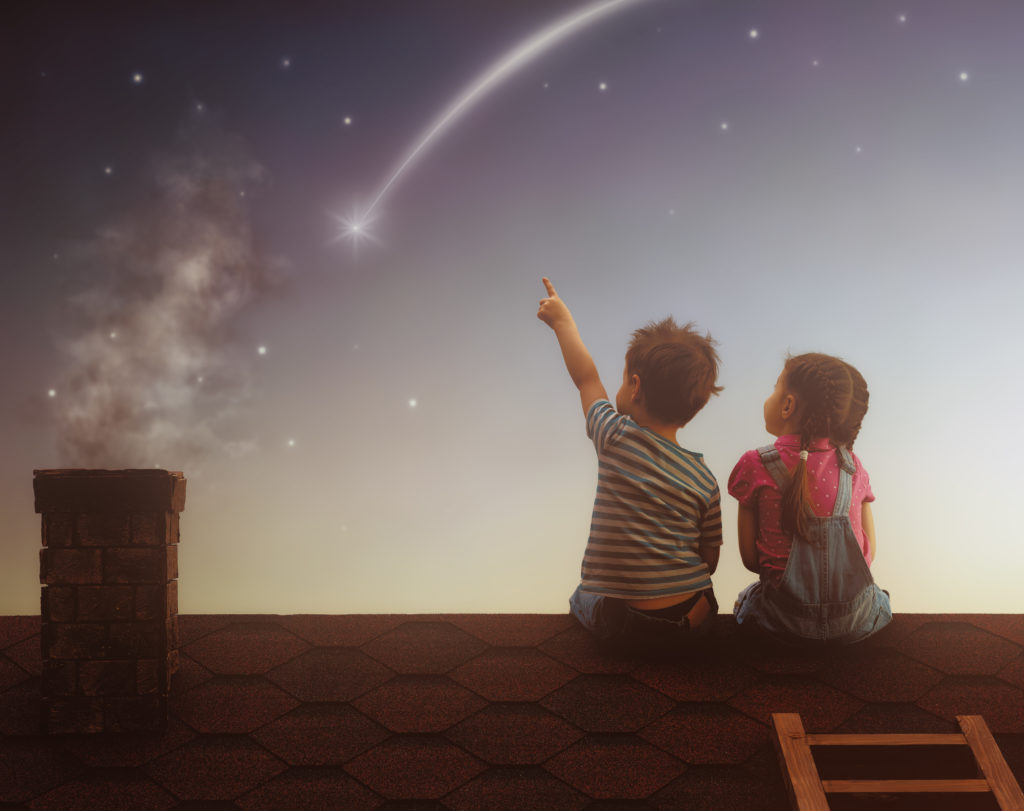kleiner Junge und Mädchen auf dem Dach sitzend, einer Sternschnuppe nachschauend